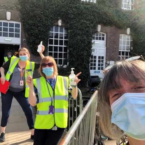 A group of three vaccination volunteers outside.