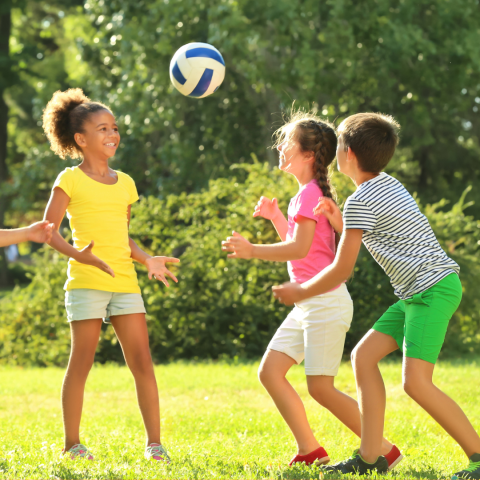 Children playing with a ball outside. 