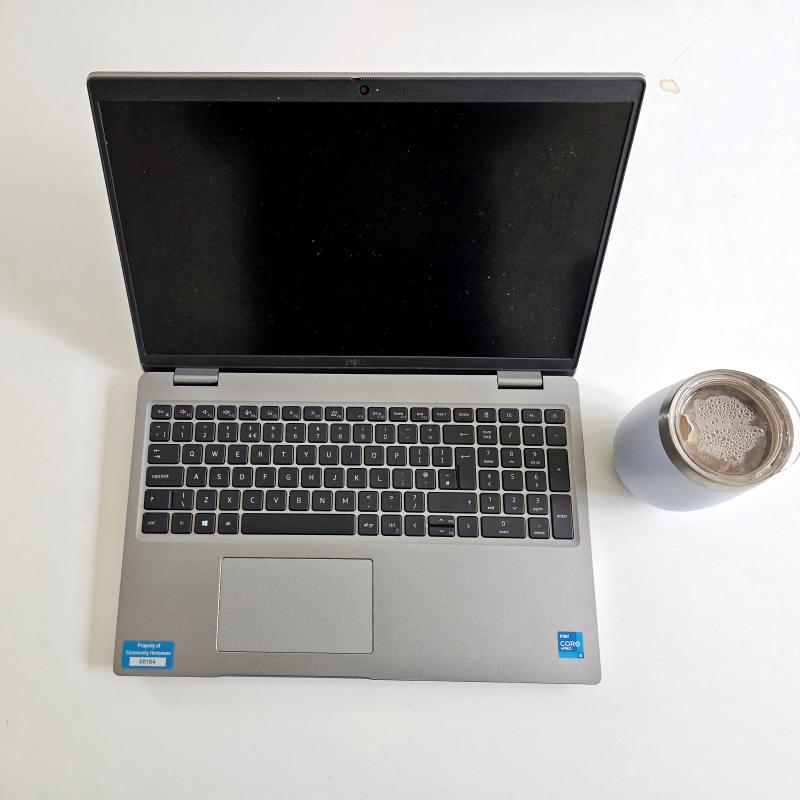 Laptop and cup of tea on a white desk. 