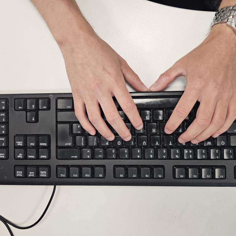 Hands typing on a keyboard.