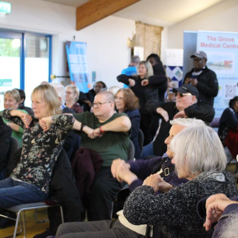 A large group of people participating in exercises you can do within a chair.