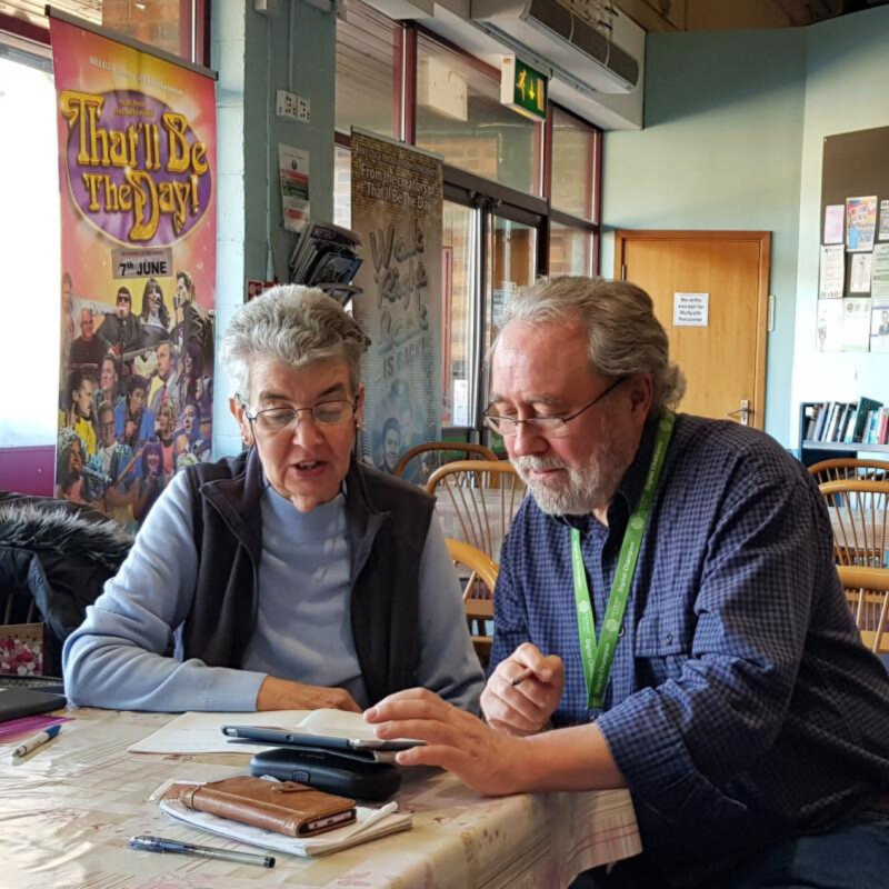 A digital champion providing tech support to a lady