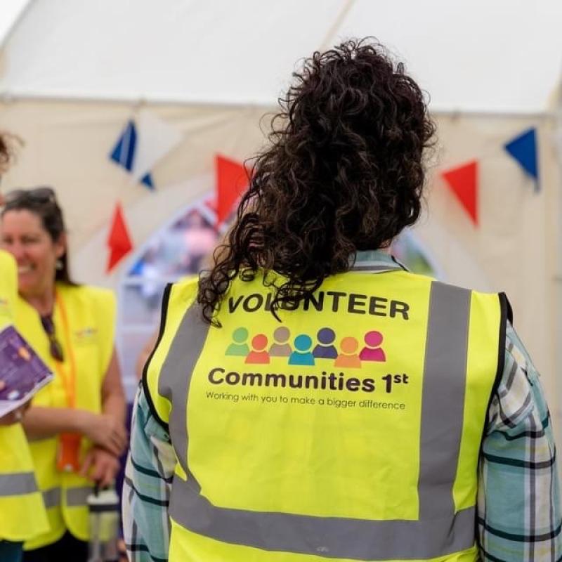 The back of a Communities 1st volunteer at an event.