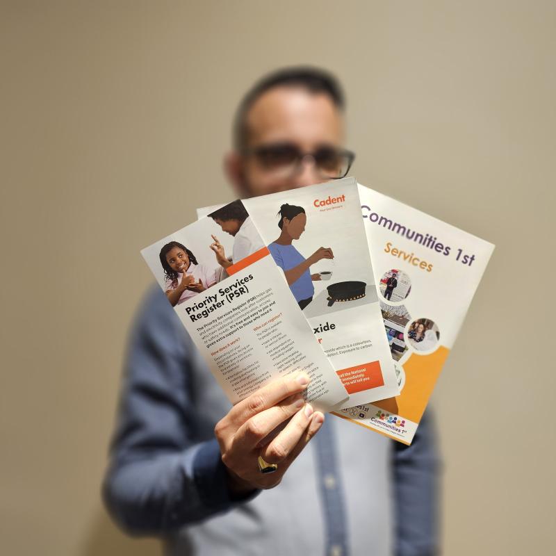 A man holding out some leaflets on energy advice