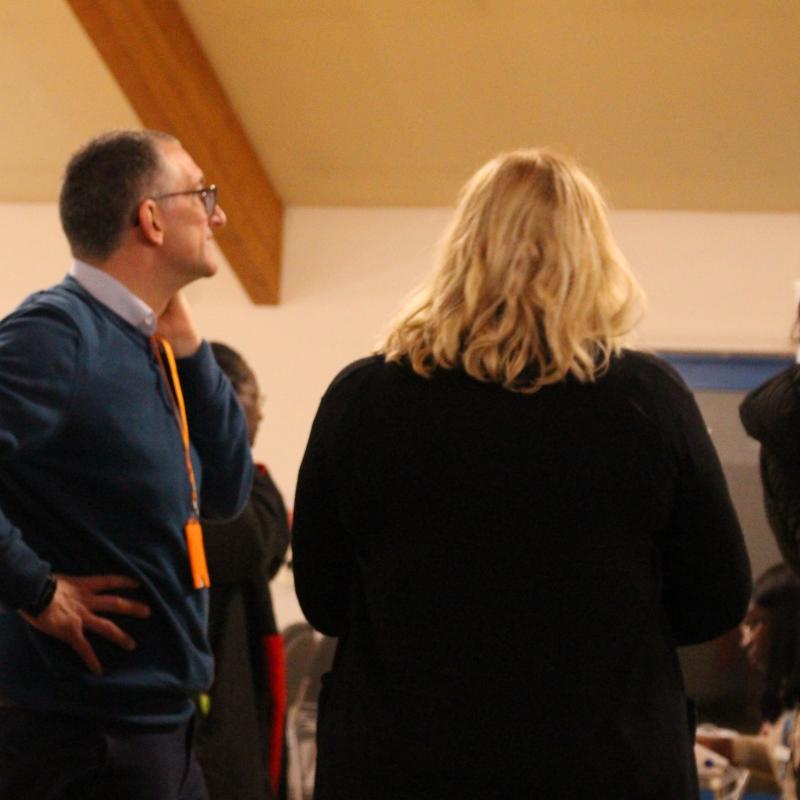Three people standing among a crowd at OHM BP Cardio Health event in November 2023.