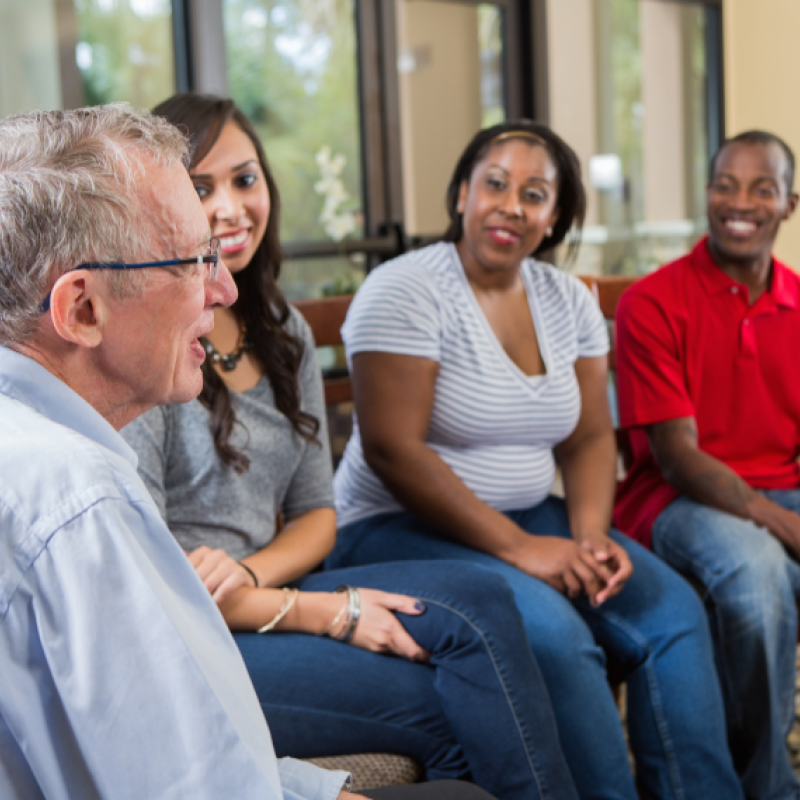 Four people sitting down and talking